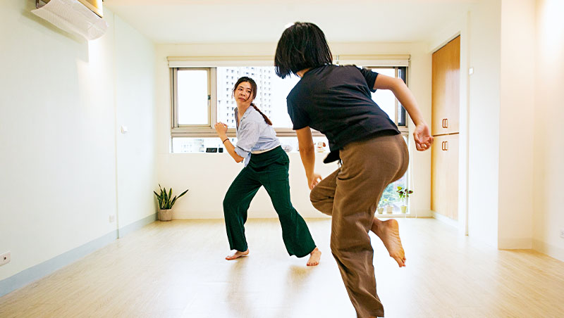 舞蹈治療師李孟寰（左）正引領學生「用一個快而輕盈的方式，做出你現在最想做的動作。」